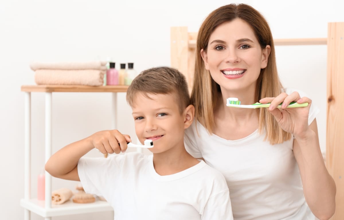 image of a mom showing her son how to brush
