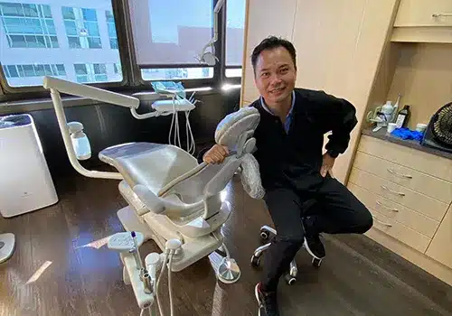 Dentist posing with dental equipment in modern office treatment room at First Hill Dental Center.