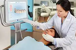 Dentist examining patient's teeth using digital imaging technology in modern dental office.