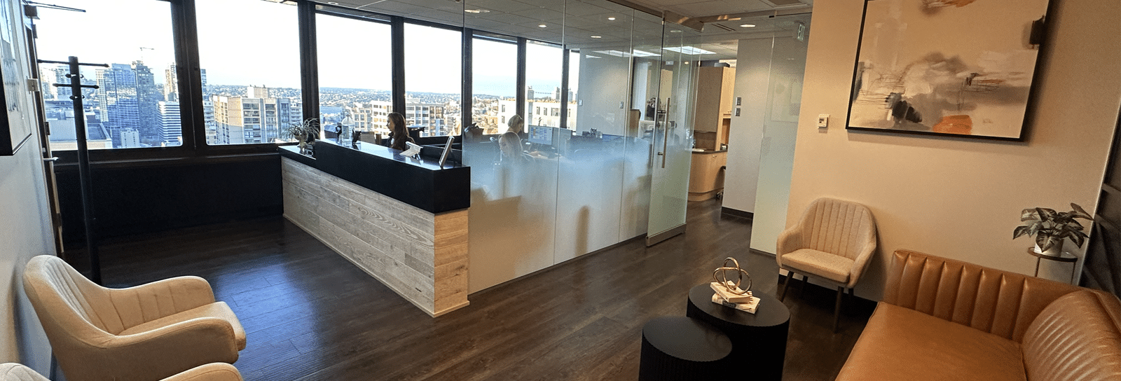 Modern dental office reception area with contemporary furniture and floor-to-ceiling windows overlooking city.