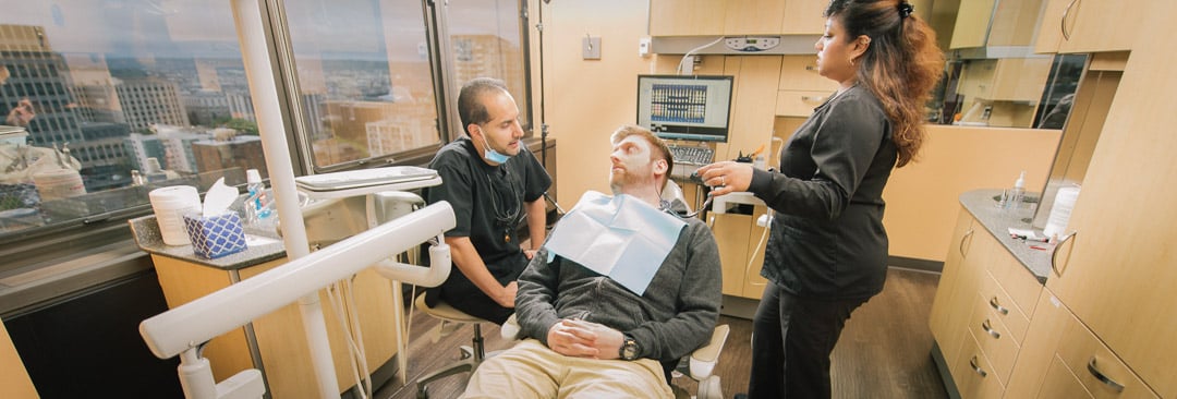Dr. Sukhdev Singh speaking with a patient during a comfortable dental visit at First Hill Dental Center in Seattle